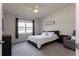 Well-lit bedroom featuring a ceiling fan, large window, and neutral decor at 10812 Applewood Range Way, Tampa, FL 33647