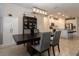 Modern dining area featuring stylish lighting, dark wood table, and seamless flow to the kitchen at 10812 Applewood Range Way, Tampa, FL 33647