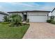 Charming single-story home featuring a well-manicured lawn, brick driveway, and a two-car garage at 10812 Applewood Range Way, Tampa, FL 33647