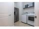 Laundry room with washer, dryer, stainless steel refrigerator and storage shelves at 10812 Applewood Range Way, Tampa, FL 33647
