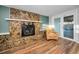 Basement fireplace area with stone surround, a wicker chair, and sliding glass doors to outside pool at 11077 87Th Ave, Seminole, FL 33772