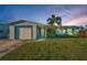 Charming one-story home featuring a well-manicured lawn, a palm tree, and a driveway leading to the attached garage at 11077 87Th Ave, Seminole, FL 33772