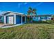 Charming one-story home featuring a well-manicured lawn, a palm tree, and a driveway leading to the attached garage at 11077 87Th Ave, Seminole, FL 33772