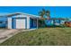 Charming one-story home featuring a well-manicured lawn, a palm tree, and a driveway leading to the attached garage at 11077 87Th Ave, Seminole, FL 33772