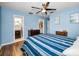 Cozy primary bedroom with blue walls, wood floors, ceiling fan, ensuite bath and closet access at 11077 87Th Ave, Seminole, FL 33772