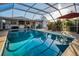 Pool area has a covered deck with a full kitchen, tv, patio table and chairs, and privacy fence at 11077 87Th Ave, Seminole, FL 33772