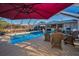 Relaxing screened pool area with an umbrella, outdoor kitchen, and ample seating for Gathering and friends at 11077 87Th Ave, Seminole, FL 33772