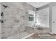 Bathroom featuring marble tile, soaking tub, glass shower, and ample natural light at 11620 Bristol Chase Dr, Tampa, FL 33626