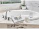 Close up of a luxurious bathtub with marble surround, plush towels, and decorative accents at 11620 Bristol Chase Dr, Tampa, FL 33626