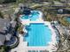 Aerial view of a resort-style community pool area with multiple pools, seating, and palm trees at 11620 Bristol Chase Dr, Tampa, FL 33626