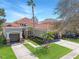 Beautiful two-story home featuring a lush green lawn, tropical landscaping, and a tile roof at 11620 Bristol Chase Dr, Tampa, FL 33626