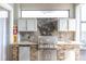 Outdoor kitchen with a stone backsplash, granite countertops, a grill, and a mini-fridge at 11620 Bristol Chase Dr, Tampa, FL 33626