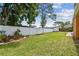 Beautiful backyard with a manicured lawn, white vinyl fence, and mature trees at 1290 Michigan Blvd, Dunedin, FL 34698