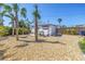 Landscaped backyard featuring palm trees and a detached two-car garage at 14066 Marguerite Dr, Madeira Beach, FL 33708