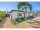 Charming home featuring a lush, tropical landscaped yard with decorative rock and a majestic palm tree at 14066 Marguerite Dr, Madeira Beach, FL 33708