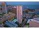 Aerial view of a high-rise condo building with a pool, offering cityscape and waterfront views at dusk at 175 1St S St # 1104, St Petersburg, FL 33701