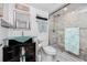 Stylish bathroom featuring glass bowl sink, dark cabinets, glass shower and a toilet at 17920 Gulf Blvd # 702, Redington Shores, FL 33708