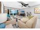 Bright living room featuring comfortable seating, ceiling fan, and sliding glass doors leading to a balcony with ocean view at 17920 Gulf Blvd # 702, Redington Shores, FL 33708