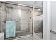 Elegant walk-in shower with marble tiling, pebble floor, and glass enclosure, for a spa-like experience at 17920 Gulf Blvd # 702, Redington Shores, FL 33708
