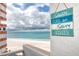 Close up of a balcony's ocean view, with a beach themed decoration on the wall at 17920 Gulf Blvd # 702, Redington Shores, FL 33708