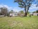 A spacious backyard with multiple storage buildings and mature trees at 18108 Crooked Ln, Lutz, FL 33548