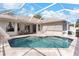 Beautiful screened-in pool with brick patio, complemented by outdoor seating and rear home view at 1911 Riveredge Dr, Tarpon Springs, FL 34689