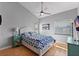 Bright main bedroom with a ceiling fan, a cozy bed with storage, and natural light from the windows at 19727 Gulf Blvd # 209, Indian Shores, FL 33785