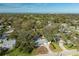Aerial view of the property showing its proximity to a golf course, the ocean and mature trees at 2050 Nigels Dr, Dunedin, FL 34698