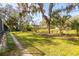 Spacious backyard with a well-maintained lawn, mature trees, and plenty of room for outdoor activities at 2050 Nigels Dr, Dunedin, FL 34698