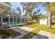 Lush backyard with screened pool, concrete patio, storage shed and mature trees provides a private retreat at 2050 Nigels Dr, Dunedin, FL 34698