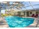 Beautiful screened in pool with clear blue water, lounge chairs, and a well-maintained deck area at 2050 Nigels Dr, Dunedin, FL 34698