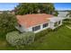 Aerial shot of a white single-story home featuring a well-manicured lawn and vibrant terra cotta roof at 2090 Iowa Ne Ave, St Petersburg, FL 33703