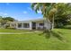 Charming single-story home featuring a well-manicured lawn and lush tropical landscaping at 2090 Iowa Ne Ave, St Petersburg, FL 33703