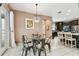 A dining room featuring a glass table, unique light fixture, and doors to the pool area at 2211 Margaret Way, Dunedin, FL 34698