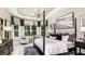 Elegant main bedroom with a tray ceiling, windows, and seating area at 29912 Rusco Ct, Wesley Chapel, FL 33545