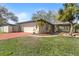 Home's exterior features a two-car garage and well-manicured landscaping with palm trees at 4002 Hudson Ter, Tampa, FL 33618