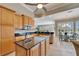 Well-lit kitchen featuring granite countertops, stainless steel appliances, and an adjacent dining area at 412 Arborview Ln, Venice, FL 34292