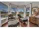 Cozy sitting area with patterned chairs and ottomans, and a picturesque view from the window at 412 Arborview Ln, Venice, FL 34292