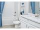 Bright, white bathroom features a tub, toilet, and vanity with modern fixtures and a blue shower curtain at 5024 124Th E Ave, Parrish, FL 34219