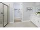 Bright bathroom featuring a glass-enclosed shower, double vanity, and access to a walk-in closet at 5024 124Th E Ave, Parrish, FL 34219