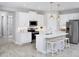 Modern kitchen featuring white cabinets, stainless steel appliances, a center island with seating, and stylish pendant lighting at 5024 124Th E Ave, Parrish, FL 34219