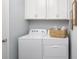 Clean laundry room with a white washer and dryer, white cabinets and decor for added convenience at 5024 124Th E Ave, Parrish, FL 34219