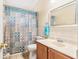 Well-lit bathroom featuring a vanity and shower with a stylish patterned curtain at 5640 Tughill Dr, Tampa, FL 33624