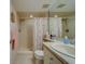 Bathroom featuring shower with seashell curtain, granite countertop sink, and mirrored wall at 6033 113Th St # 213, Seminole, FL 33772
