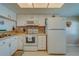 Bright kitchen with white appliances and cabinets, complemented by granite countertops at 6033 113Th St # 213, Seminole, FL 33772