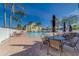 Community pool area features tables, umbrellas, lounge chairs, and palm trees in a resort-style setting at 6033 113Th St # 213, Seminole, FL 33772