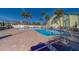 Community pool and lounge area with several seating options and palm trees at 6033 113Th St # 213, Seminole, FL 33772