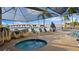 Inviting hot tub area with lounge chairs and umbrellas, offering a serene retreat with views of the bridge at 6083 Bahia Del Mar Cir # 359, St Petersburg, FL 33715