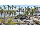 View of a parking lot with lush landscaping and a serene water feature with palm trees in the background at 6083 Bahia Del Mar Cir # 359, St Petersburg, FL 33715