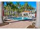 Community pool surrounded by palm trees, lounge chairs, and umbrellas at 6083 Bahia Del Mar Cir # 359, St Petersburg, FL 33715